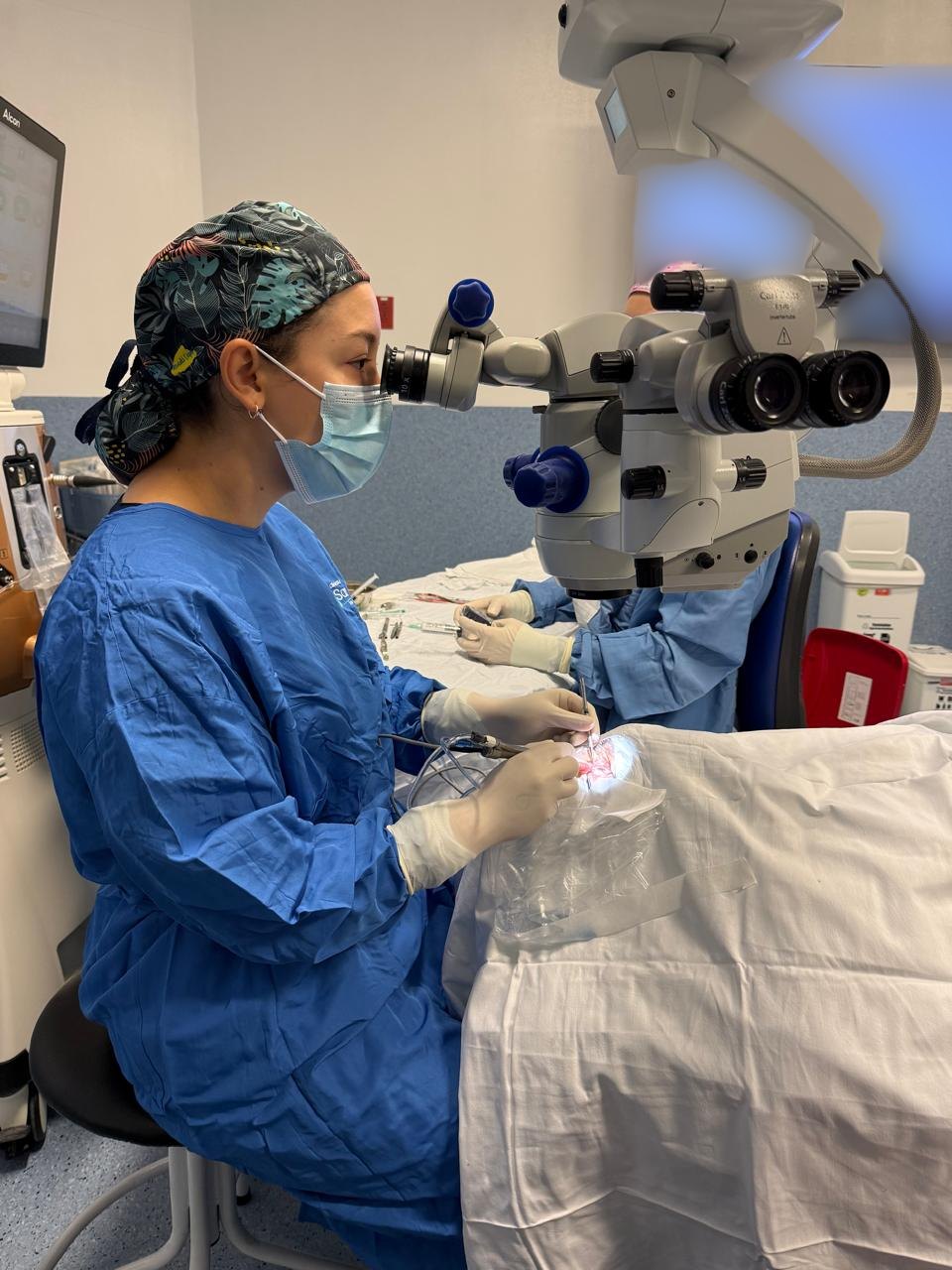 La Dra. Sara Ospina operando con el microscopio quirúrgico